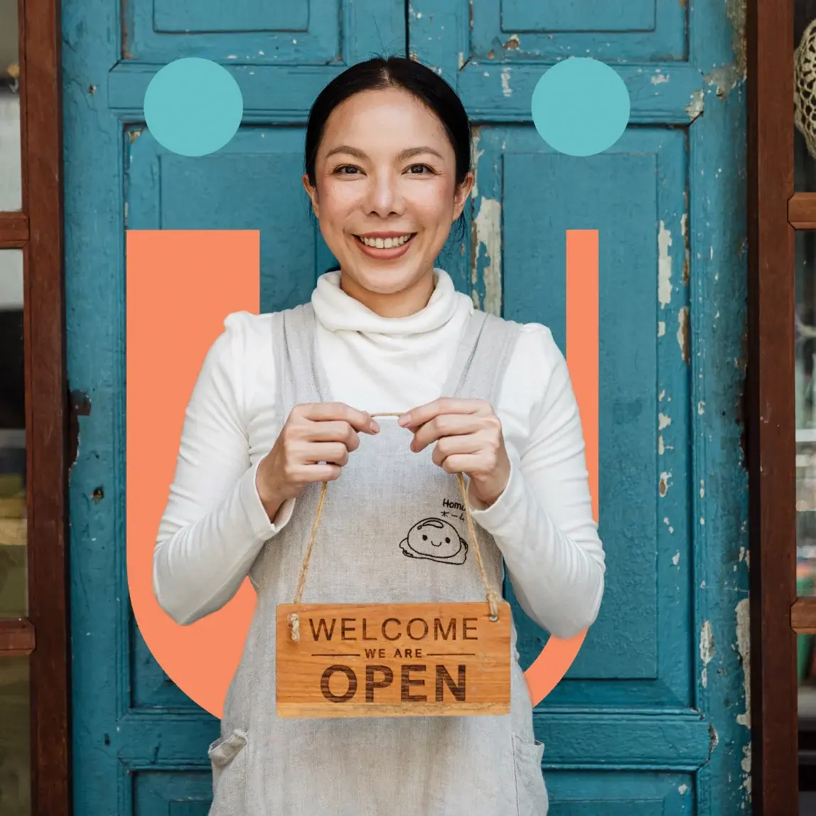 The same owner holding a “Welcome, we are open” sign, framed by the coral U and teal dots of the brand’s image treatment.