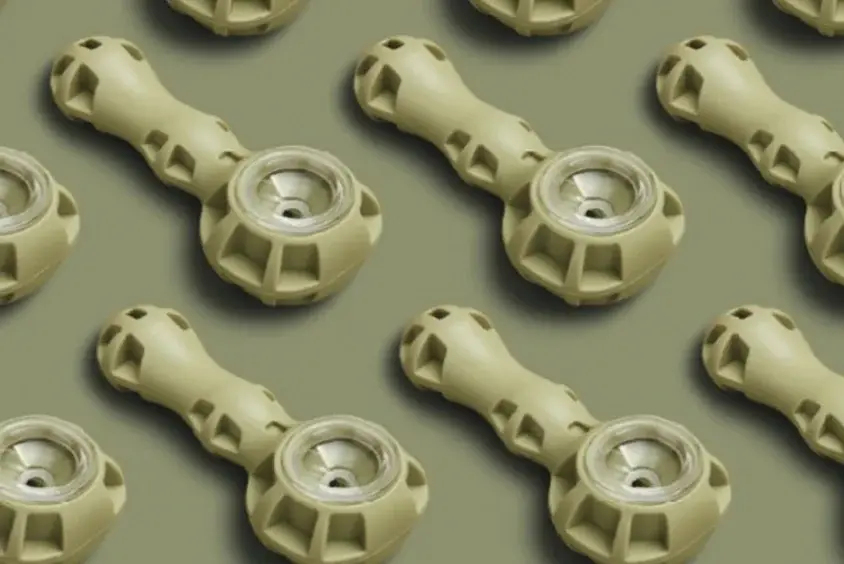 A repeating pattern of pale ceramic pipes laid out in rows on sage.