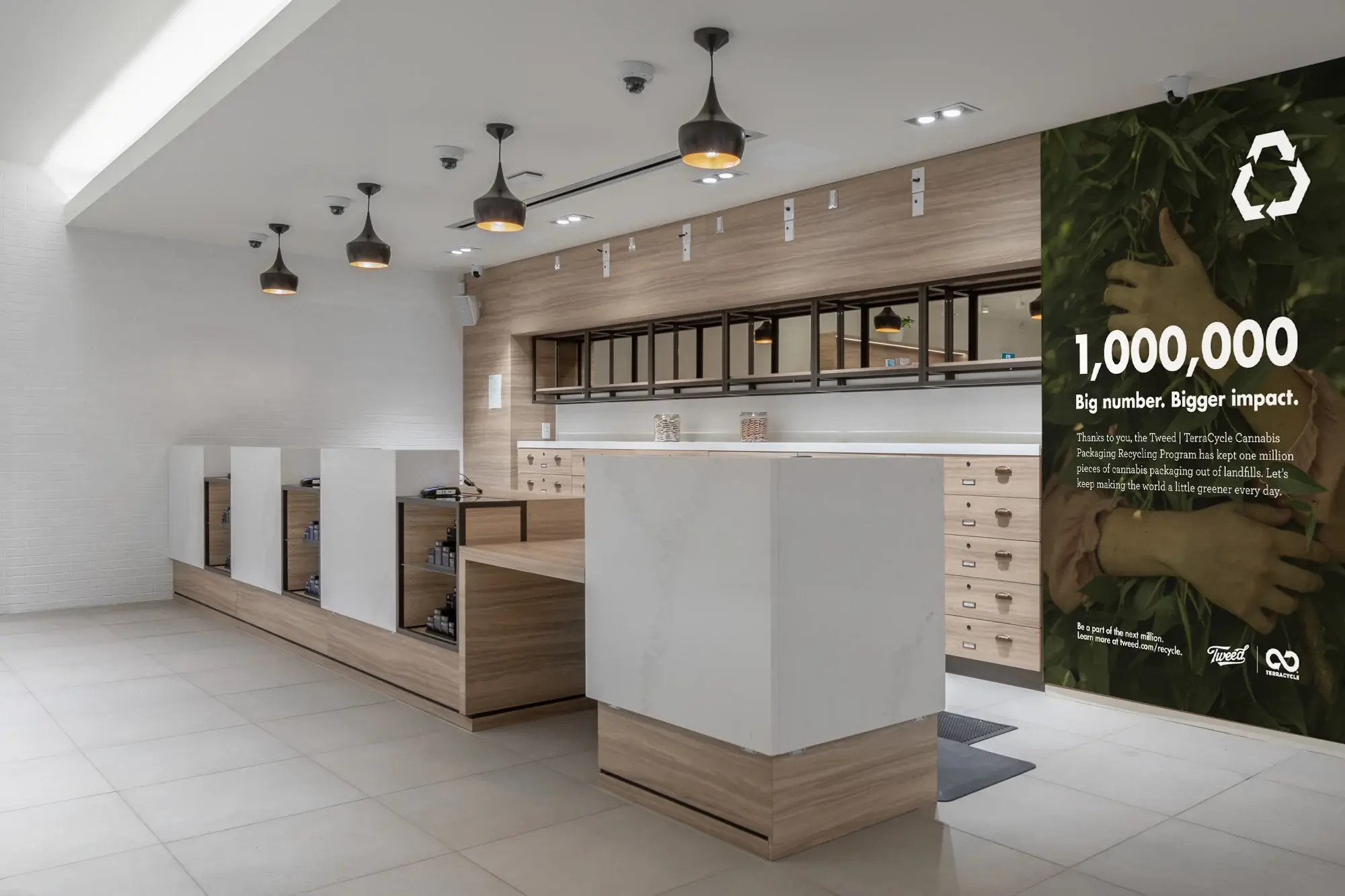 The same milestone artwork installed full height in a Tweed store, beside the counter and product wall.